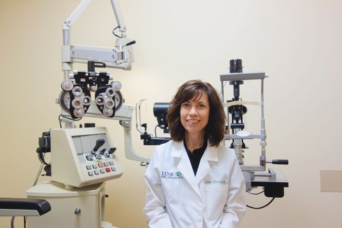 " Dr. Susan Donald, scleral lenses expert at Lusk Eye Specialist with eye treatment machine"